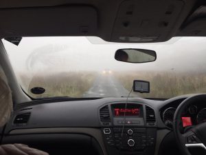 a foggy road looking through a windshield