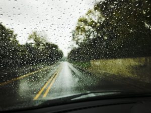 a slick road looking through a rainy windshield