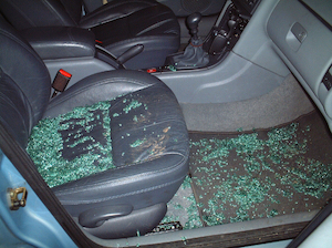 passenger side of a vehicle with shattered glass on the floor board